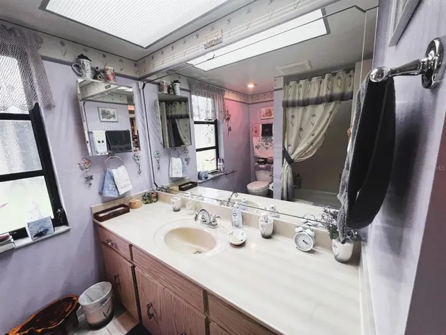 a kitchen area with lots of clutter and chairs