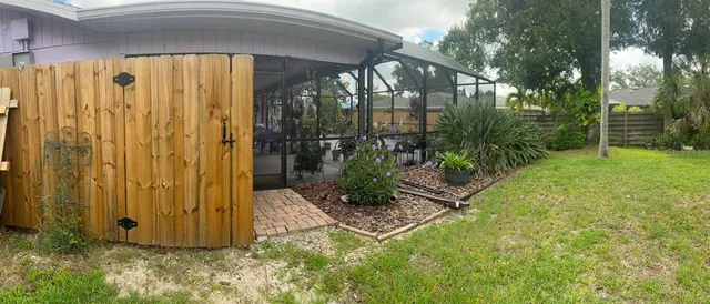 a view of a backyard with a table and chairs under an umbrella