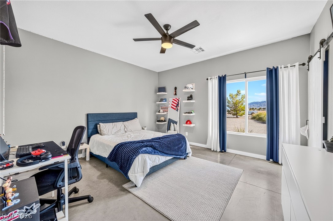 4080 Magnet Road Pahrump, NV 89048 - Photo 14 of 28 High ceilings and polished concrete floors define this spacious bedroom layout.