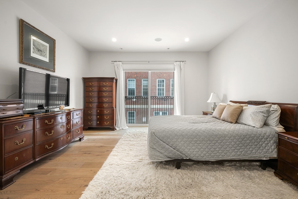205 E Street, Unit 8N Boston, MA 02127 - Photo 13 of 29 a spacious bedroom with a bed and a flat screen tv