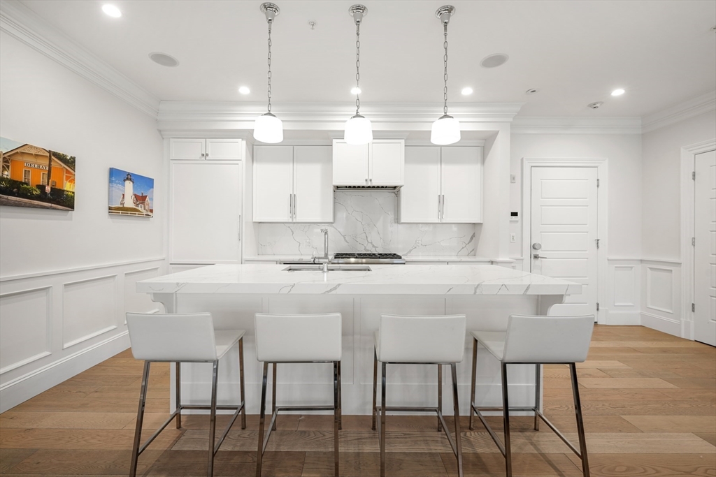 205 E Street, Unit 8N Boston, MA 02127 - Photo 5 of 29 a white kitchen with a table and chairs in it