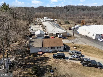an aerial view of a house with a mountain