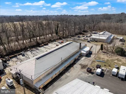 a view of a roof deck with couches and a flat umbrella next to a yard