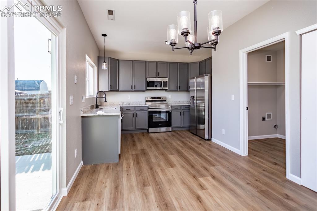 890 Rancher Drive Fountain, CO 80817 - Photo 15 of 42 Notice the beautiful light fixtures through, LVP flooring, and the laundry room to the right.