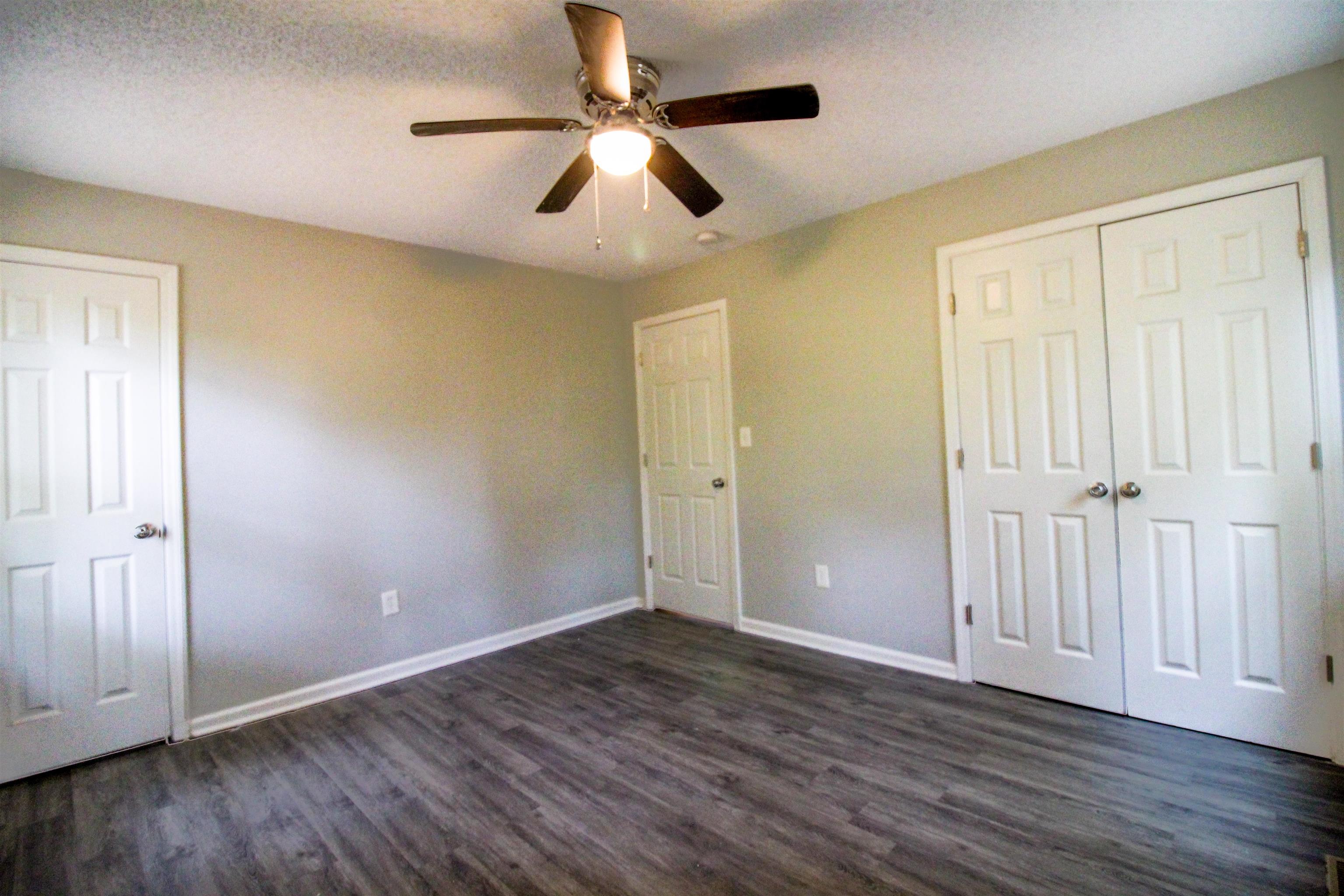 2089 Ralph Road Covington, TN 38019 - Photo 12 of 28 Bedroom featuring dark wood-style flooring, a ceiling fan, a textured ceiling, and a closet & Full Bath