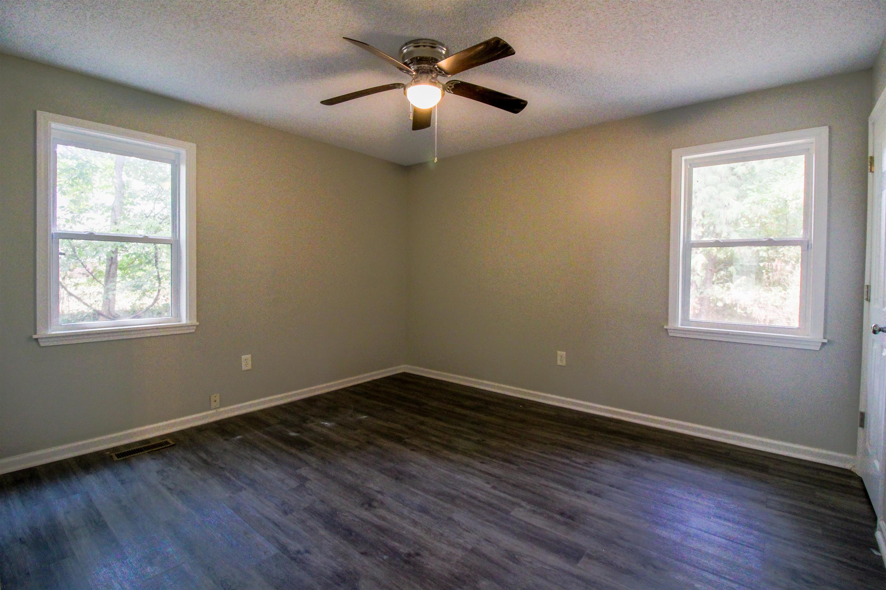 2089 Ralph Road Covington, TN 38019 - Photo 13 of 28 Bedroom featuring dark wood-style flooring, a ceiling fan, a textured ceiling, and a closet & Full Bath