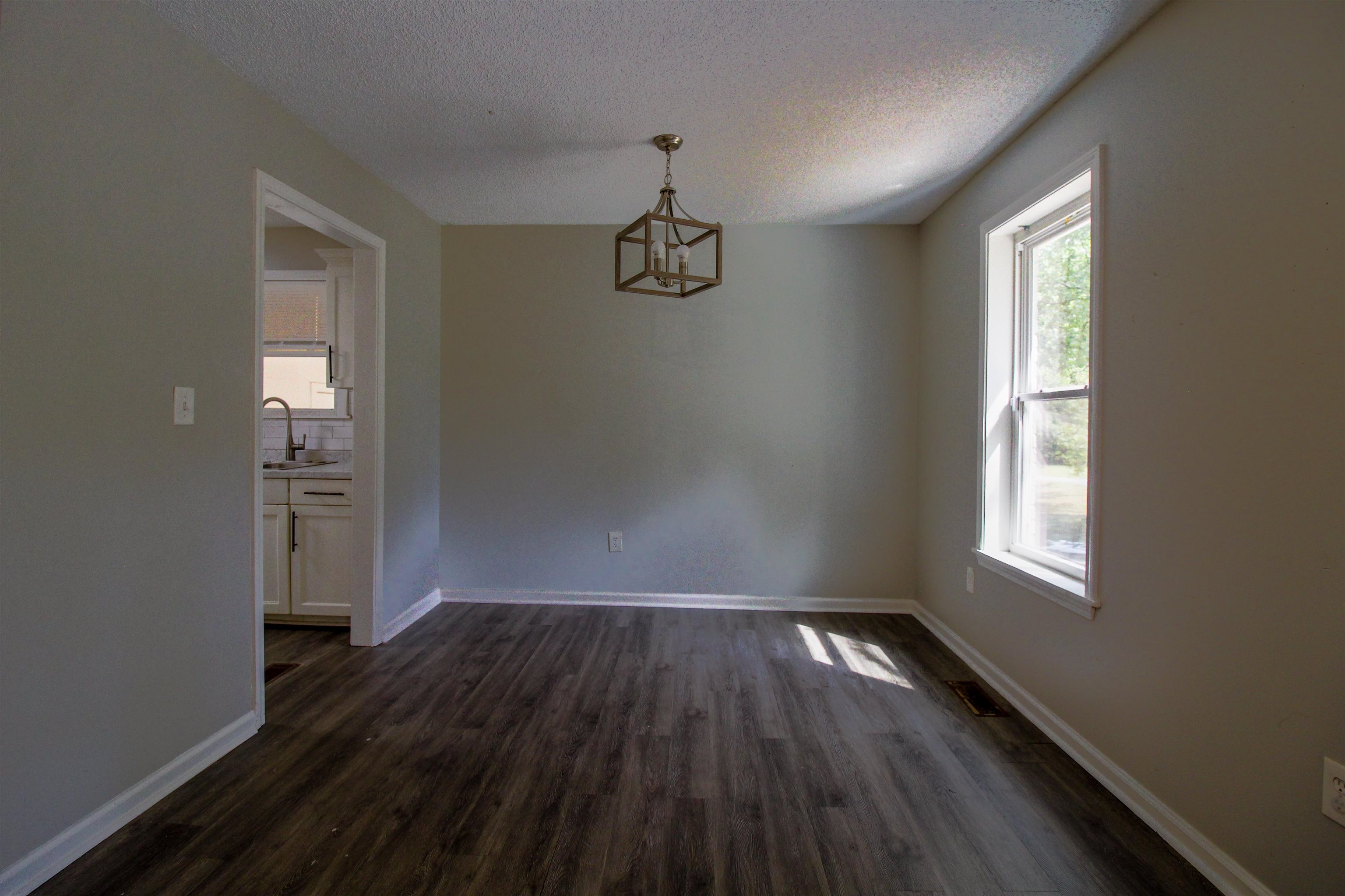 2089 Ralph Road Covington, TN 38019 - Photo 8 of 28 Dining area with dark wood finished floors, a textured ceiling, and a chandelier