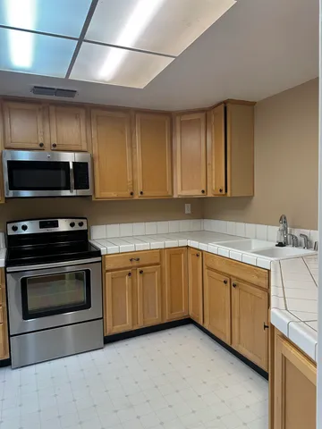 a kitchen with granite countertop a sink and a stove top oven