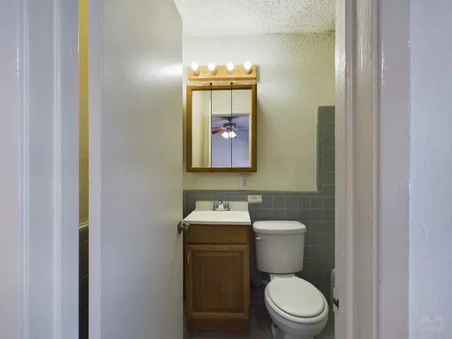 a bathroom with a toilet a sink and mirror