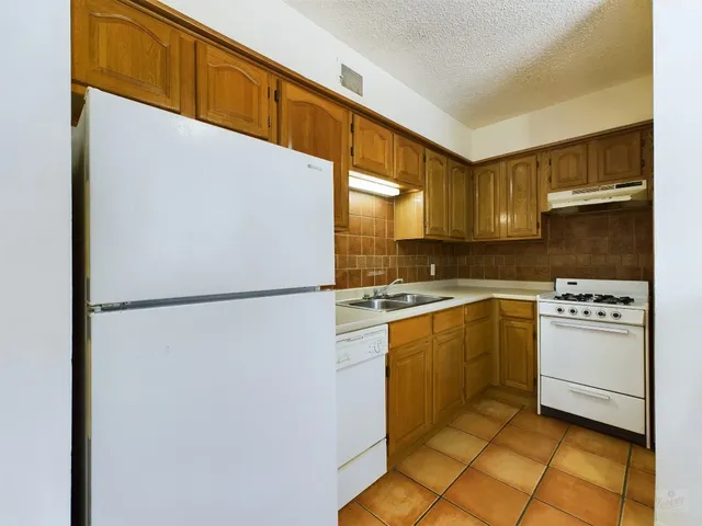 a kitchen with a refrigerator and a more cabinets