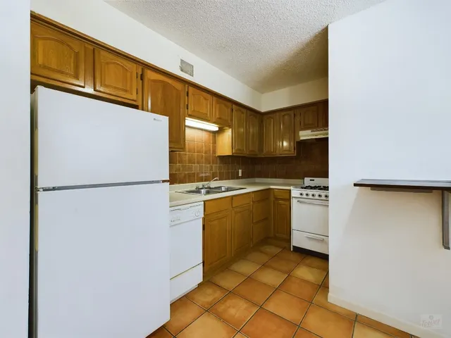 a view of a big room with windows and chandelier fan
