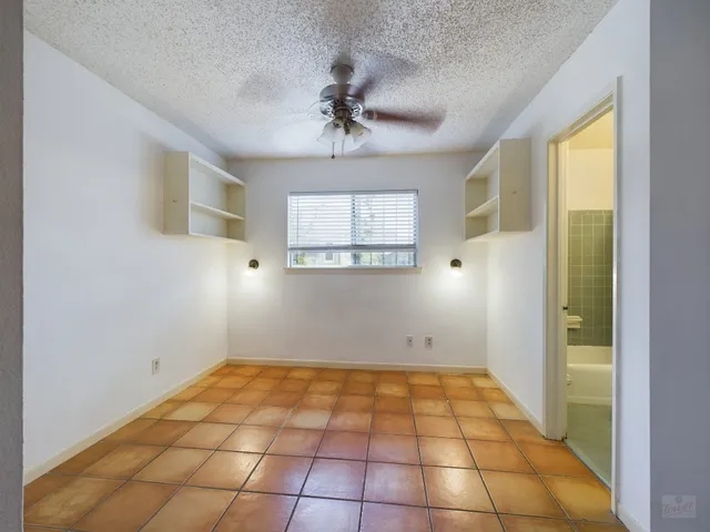 a view of a hallway with wooden floor and a bathroom