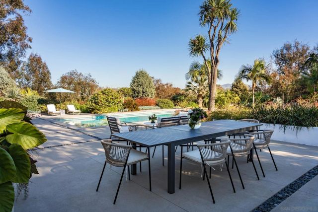 a view of a patio with table and chairs with wooden floor and plants