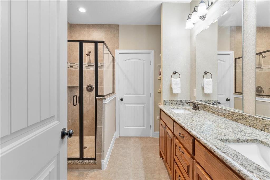 502 Ritchey Street Gainesville, TX 76240 - Photo 22 of 29 a bathroom with a granite countertop sink and a mirror