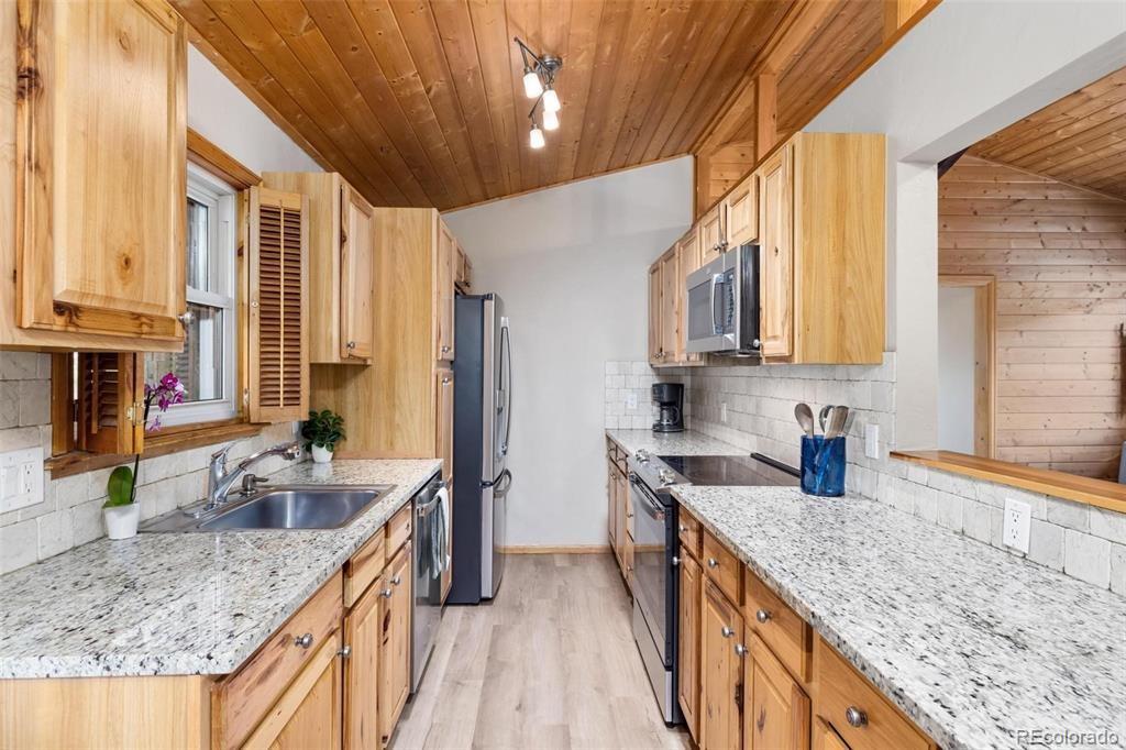 27 East Hanson Road Dillon, CO 80435 - Photo 3 of 25 a kitchen with stainless steel appliances granite countertop a sink a stove and a wooden cabinets