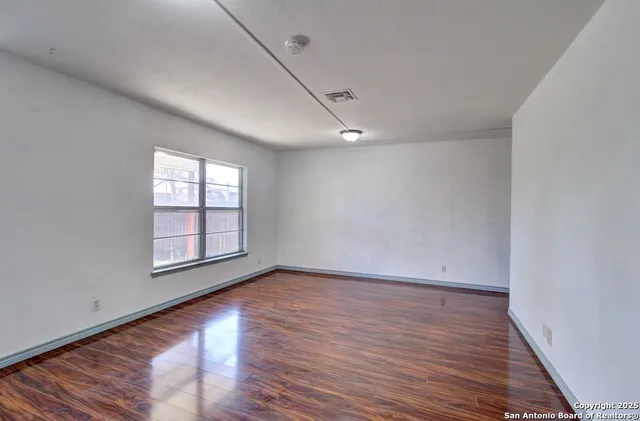 wooden floor in an empty room with a window