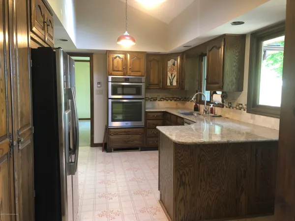 a kitchen with kitchen island a sink appliances and cabinets
