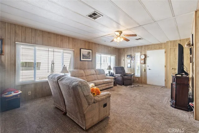 a living room with furniture a ceiling fan and a window