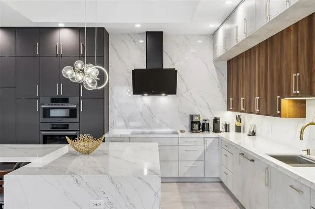 a kitchen with kitchen island granite countertop a sink and a stove top oven