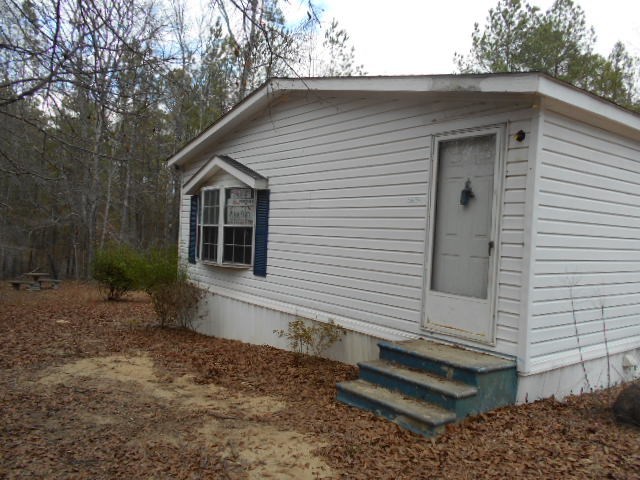 5654 Fulton Mill Road Lizella, GA 31052 - Photo 2 of 12 a small white house with a white roof and wooden fence