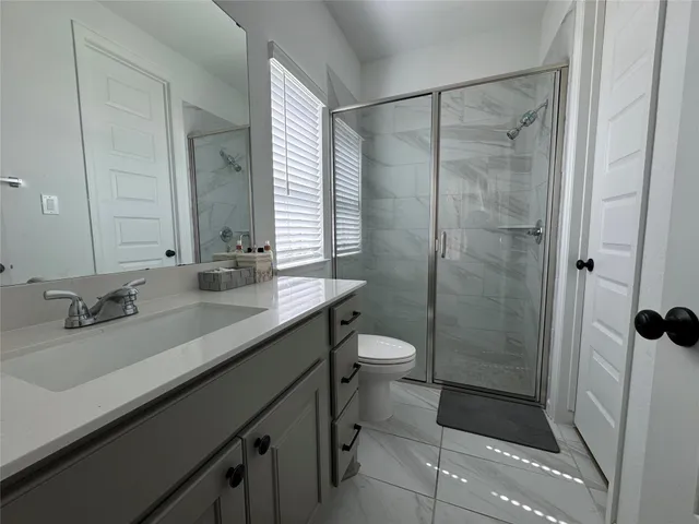 a bathroom with a double vanity sink toilet and shower