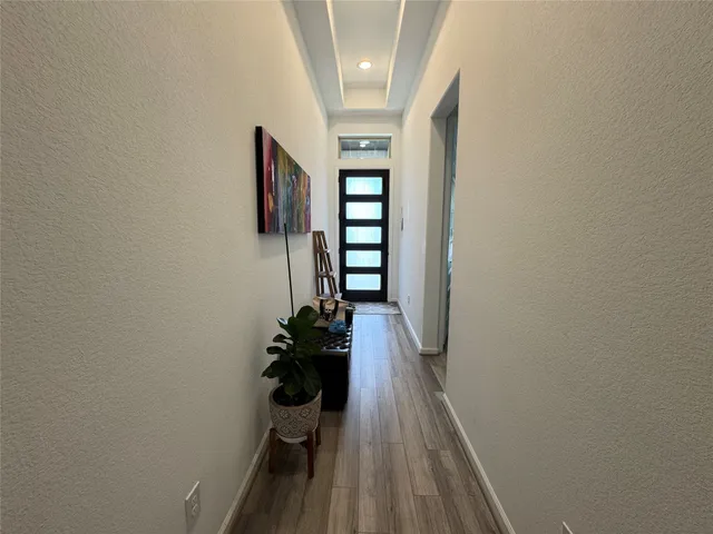 a view of a hallway with wooden floor and staircase