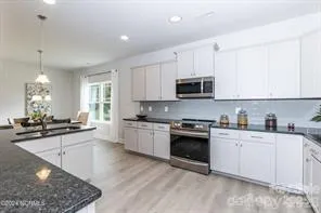 a kitchen with stainless steel appliances granite countertop a stove sink and cabinets