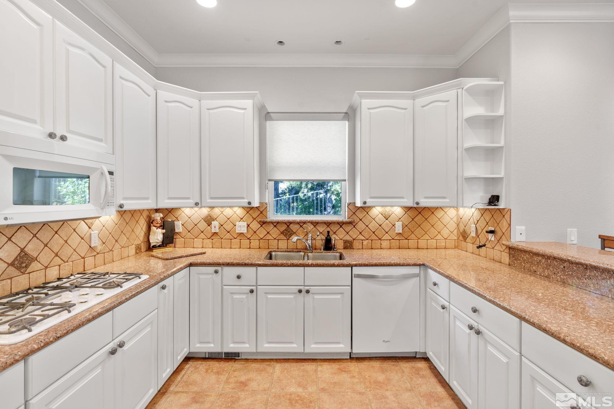 3950 Plateau Road Reno, NV 89519 - Photo 11 of 37 a kitchen with granite countertop white cabinets and white appliances