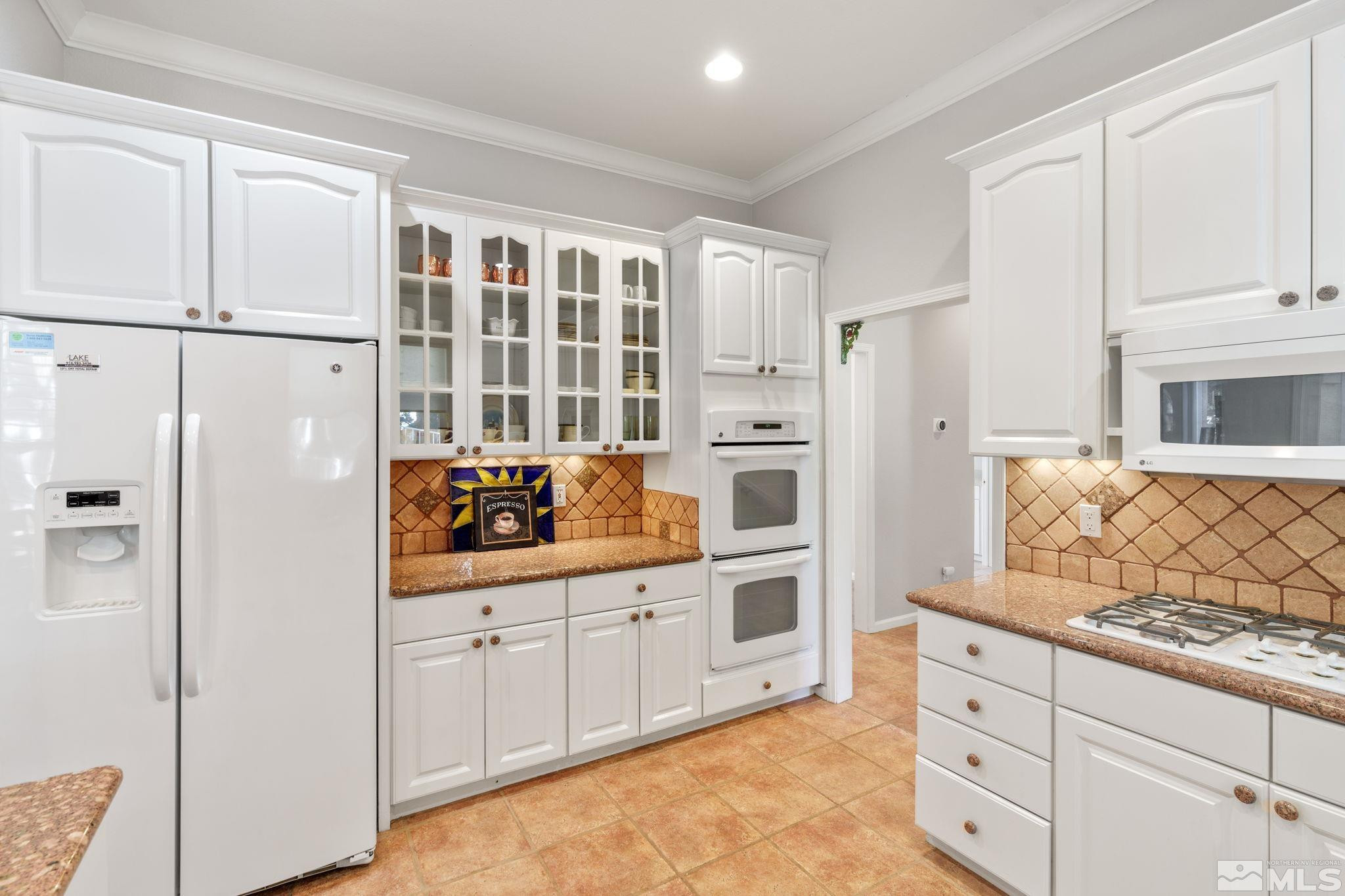 3950 Plateau Road Reno, NV 89519 - Photo 12 of 37 a kitchen with white cabinets and refrigerator