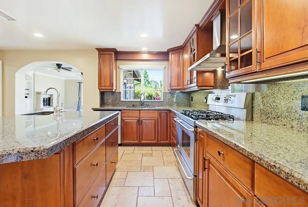 12858 Stone Canyon Road Poway, CA 92064 - Photo 11 of 57 a kitchen with stainless steel appliances granite countertop a stove a sink and a microwave