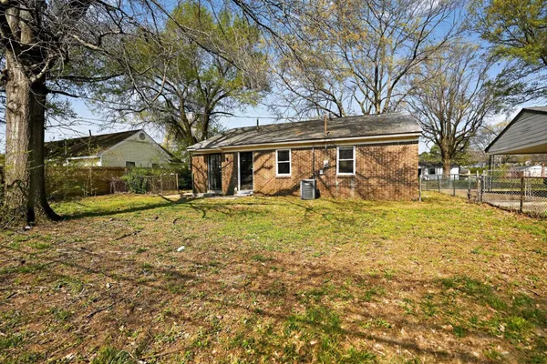 a front view of a house with a yard and trees