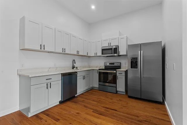 a kitchen with a refrigerator stove and white cabinets