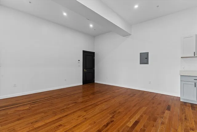 a view of an empty room with wooden floor