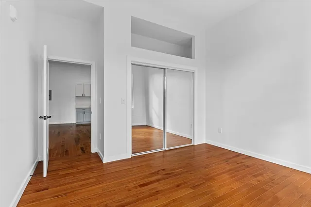 a view of empty room with wooden floor