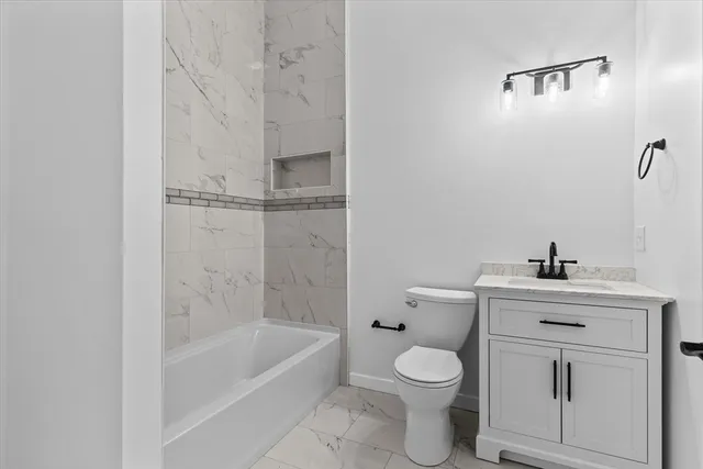 a white toilet sitting next to a bath tub