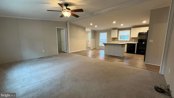 a view of an empty room and kitchen view