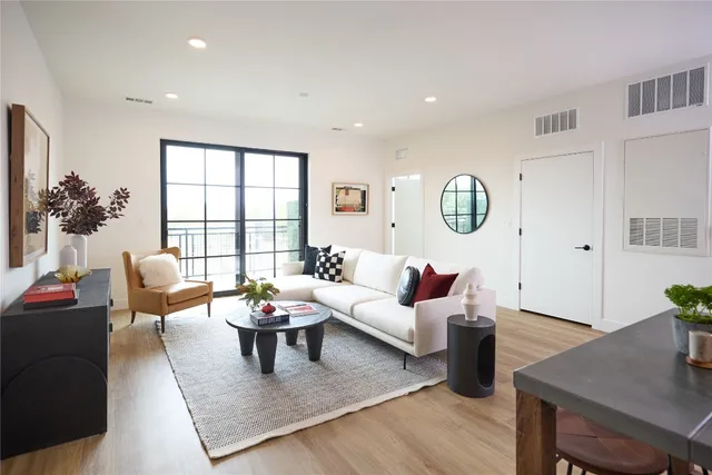 a living room with furniture potted plant and a large window