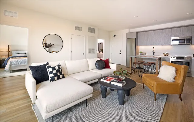 a living room with furniture a rug and white walls
