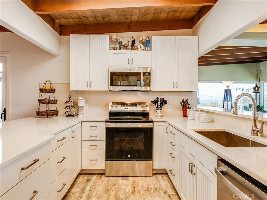 430 Olive Street Morro Bay, CA 93442 - Photo 18 of 68 a kitchen with cabinets stainless steel appliances a sink and a stove