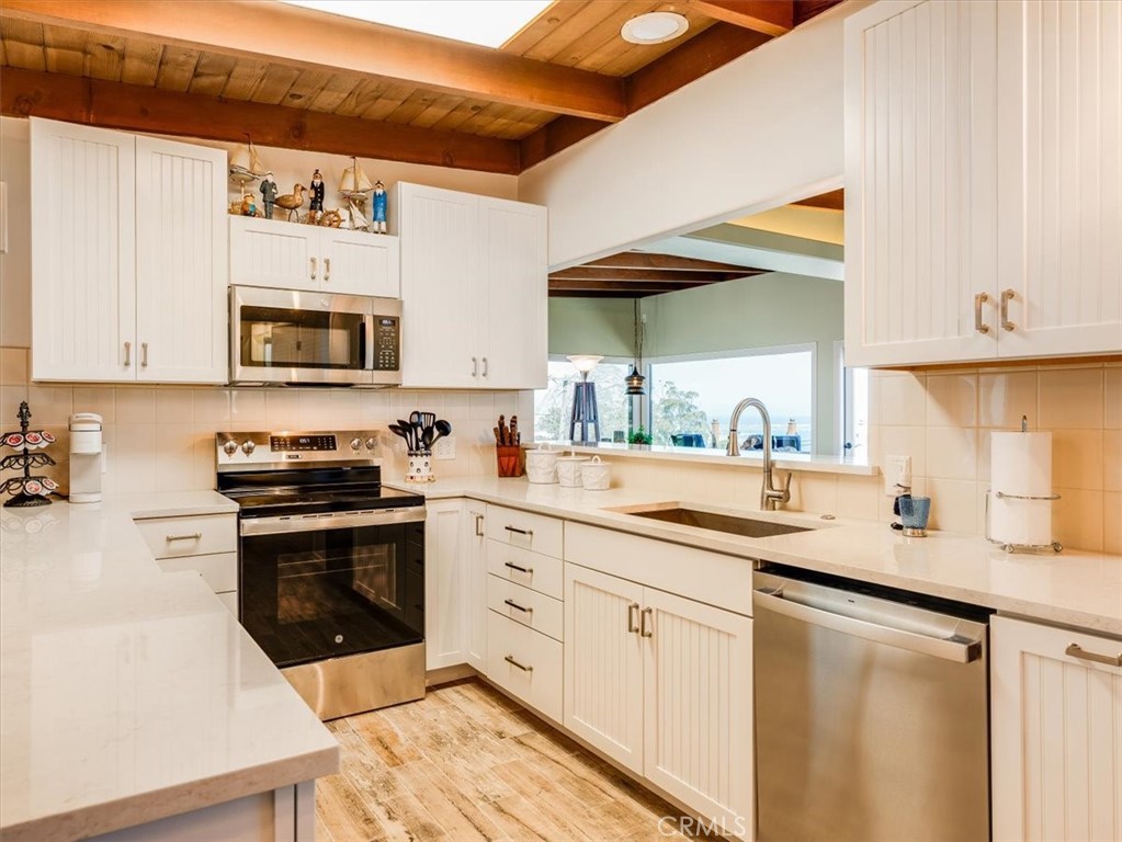 430 Olive Street Morro Bay, CA 93442 - Photo 19 of 68 a kitchen with stainless steel appliances granite countertop a sink and cabinets