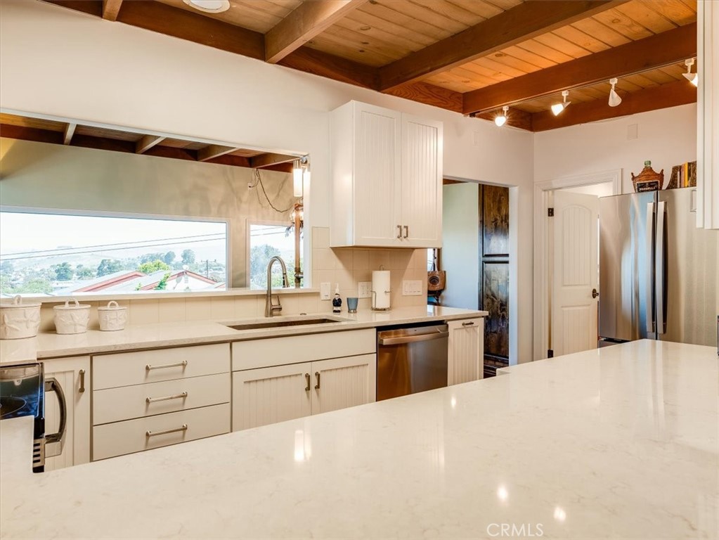 430 Olive Street Morro Bay, CA 93442 - Photo 20 of 68 a large white kitchen with sink and cabinets