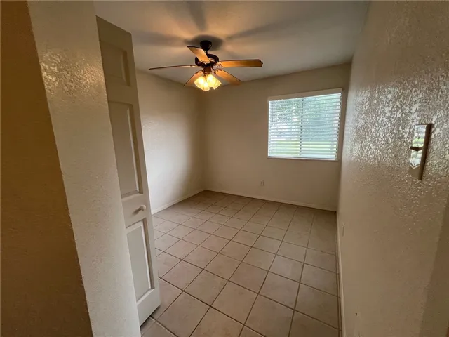 an empty room with closet and a chandelier fan