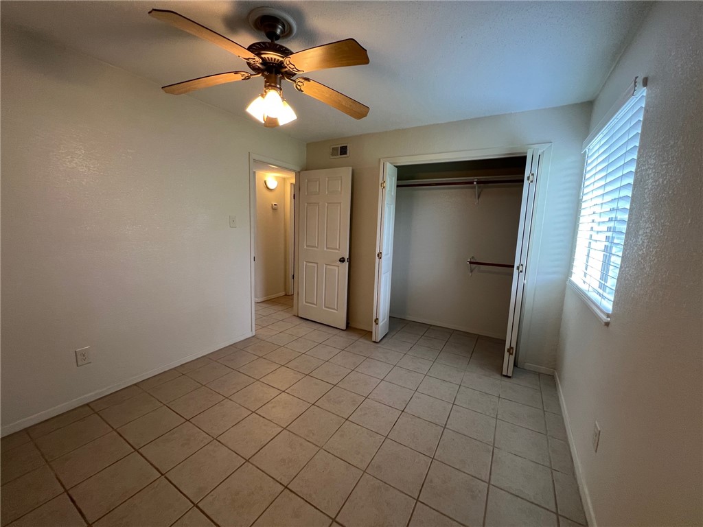 808 Natalie Street, Unit A Bryan, TX 77801 - Photo 4 of 8 an empty room with closet and a chandelier fan
