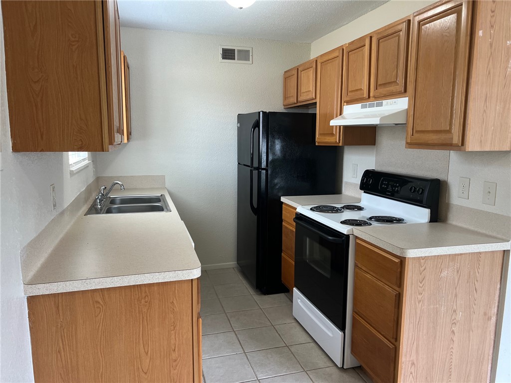 808 Natalie Street, Unit A Bryan, TX 77801 - Photo 7 of 8 a kitchen with a sink a stove and a refrigerator