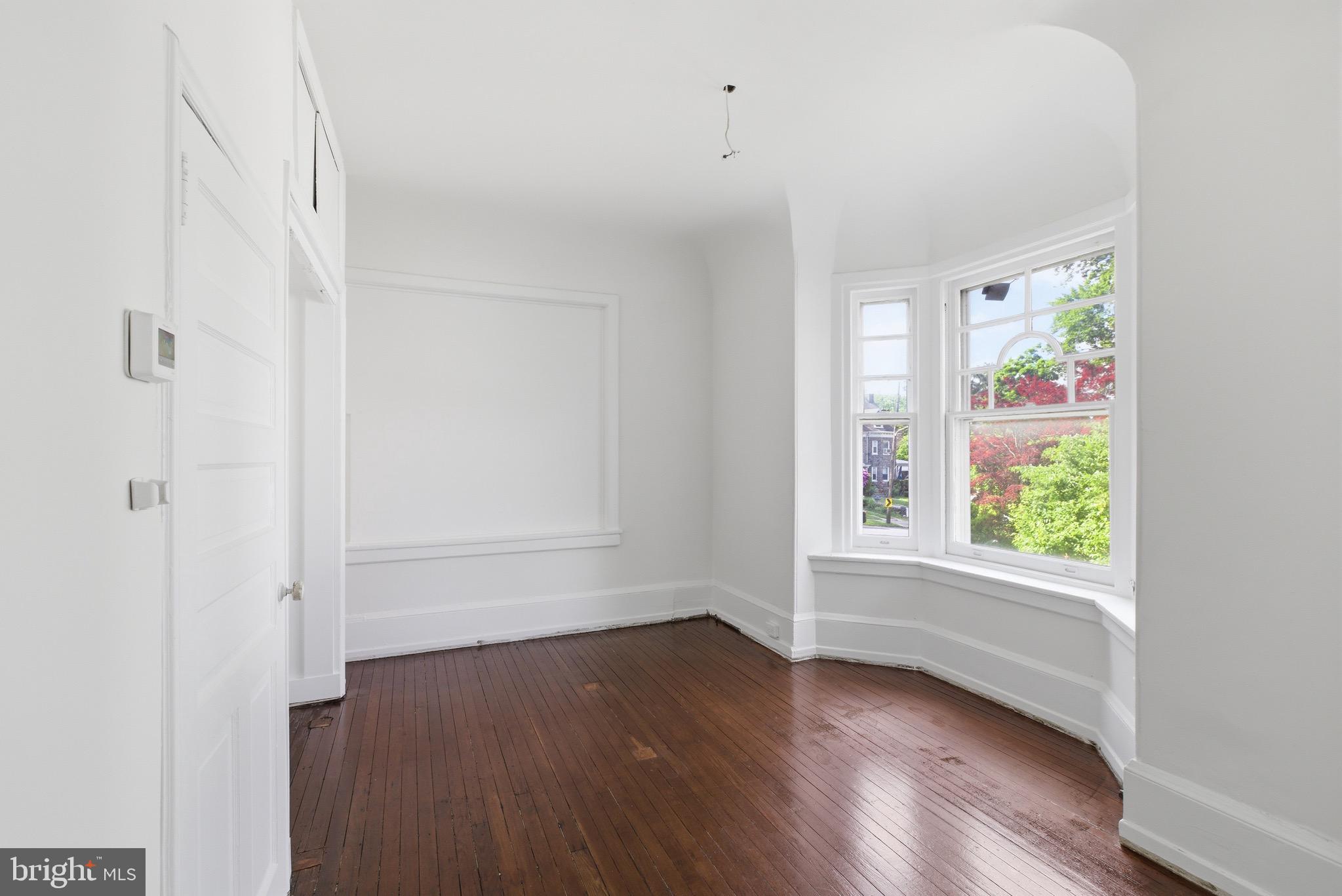 5939 Drexel Road, Unit 1 Philadelphia, PA 19131 - Photo 5 of 16 an empty room with wooden floor and window