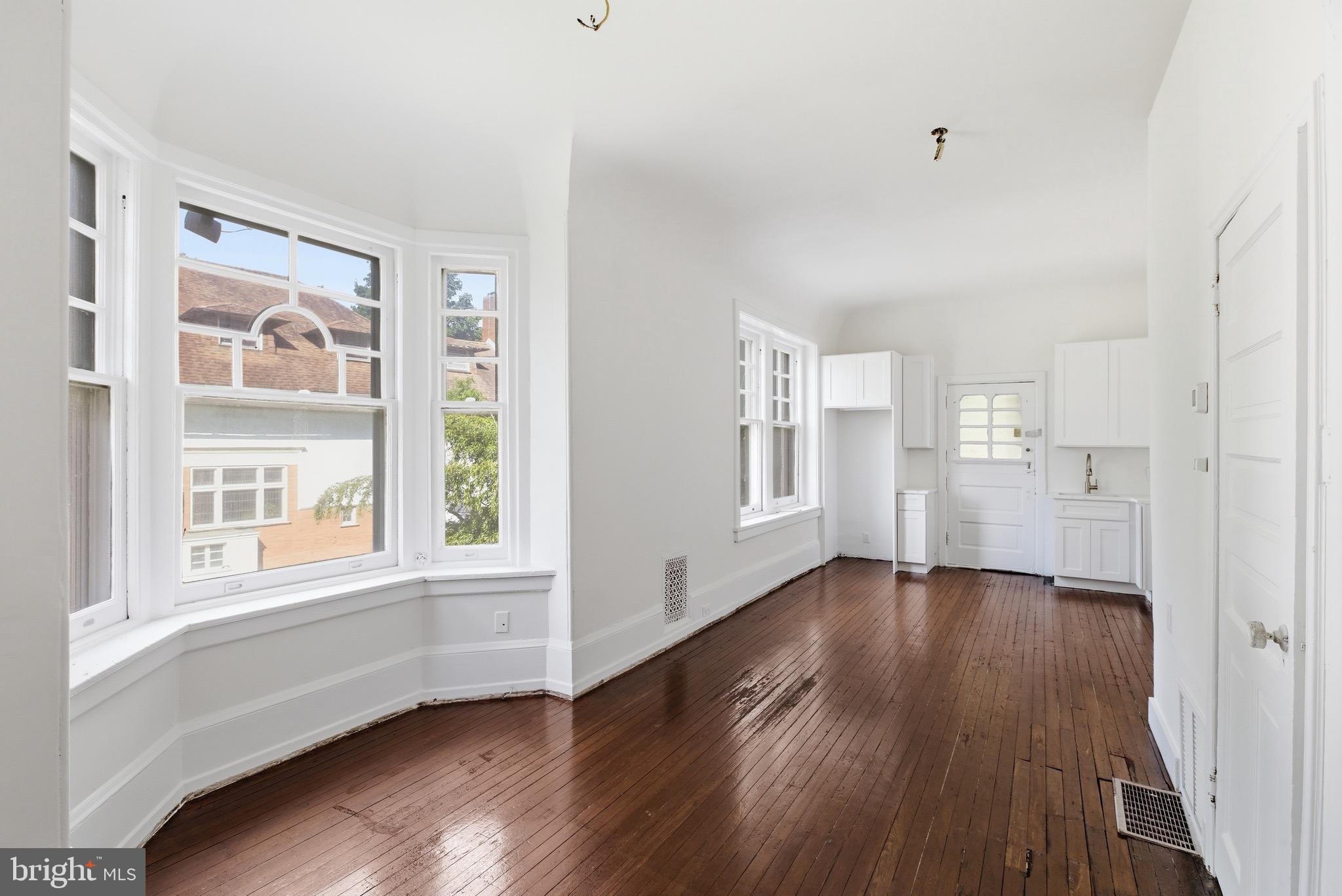 5939 Drexel Road, Unit 1 Philadelphia, PA 19131 - Photo 6 of 16 a view of an empty room with wooden floor and a window