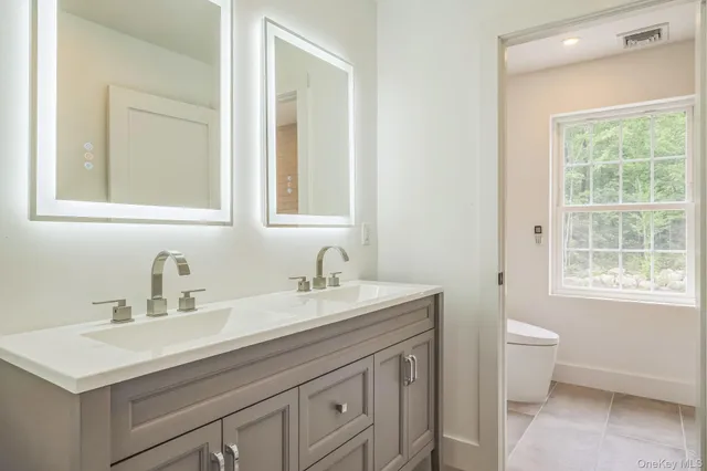 a bathroom with a sink toilet and a window