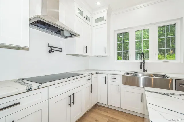 a kitchen with a sink dishwasher and white cabinets