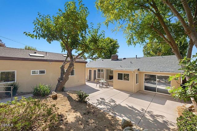 a front view of a house with a yard and potted plants