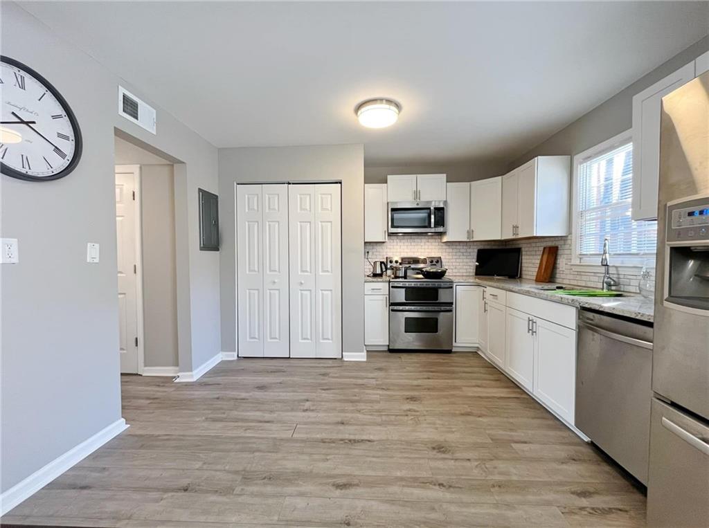 6520 Roswell Road, Unit 3 Atlanta, GA 30328 - Photo 15 of 47 a kitchen with kitchen island granite countertop white cabinets and stainless steel appliances